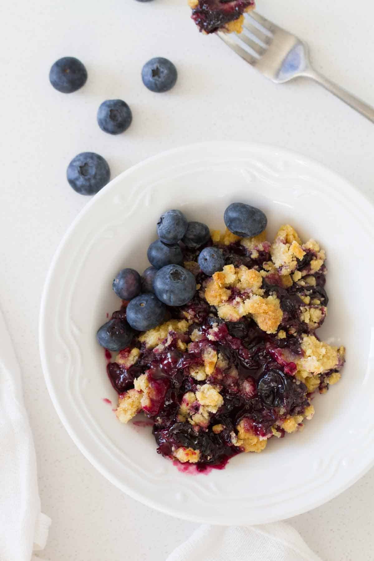 bowl with fruit crisp and fresh blueberries