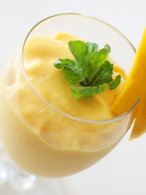 Mango Batido in a glass with mint and fresh mango