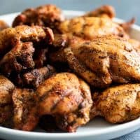 grilled chicken thighs on a white plate