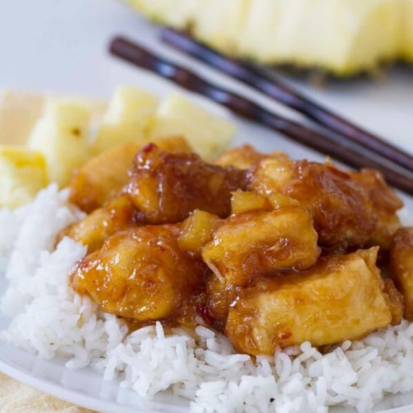 pineapple chicken over rice on a plate