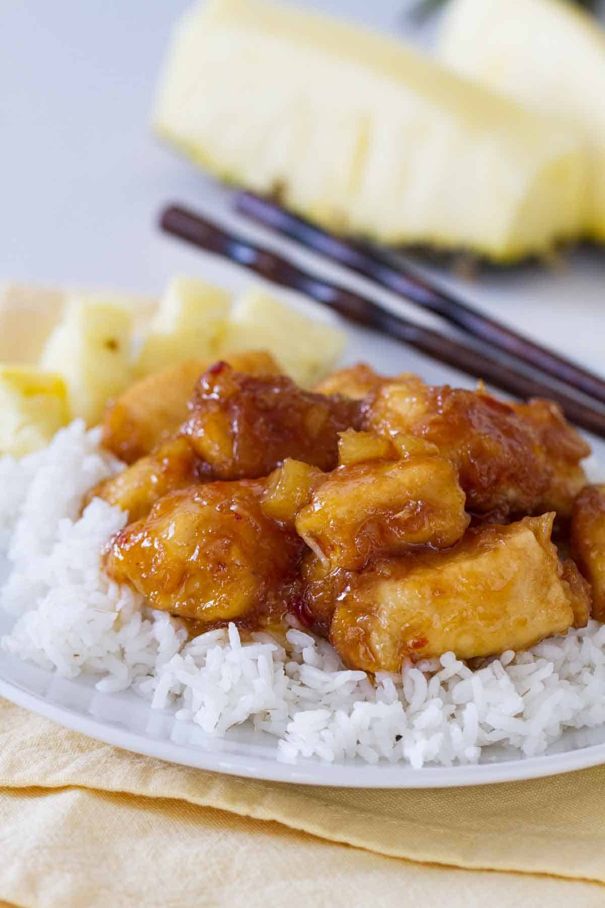 pineapple chicken over rice on a plate