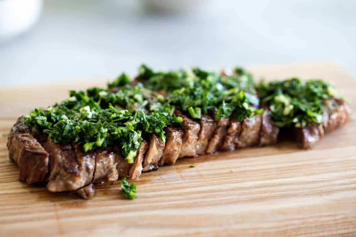 grilled steak topped with chopped parsley