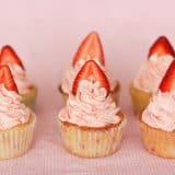 6 strawberry cupcakes with strawberry slices on top.