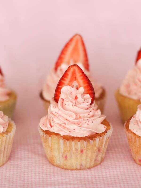 6 strawberry cupcakes with strawberry slices on top.