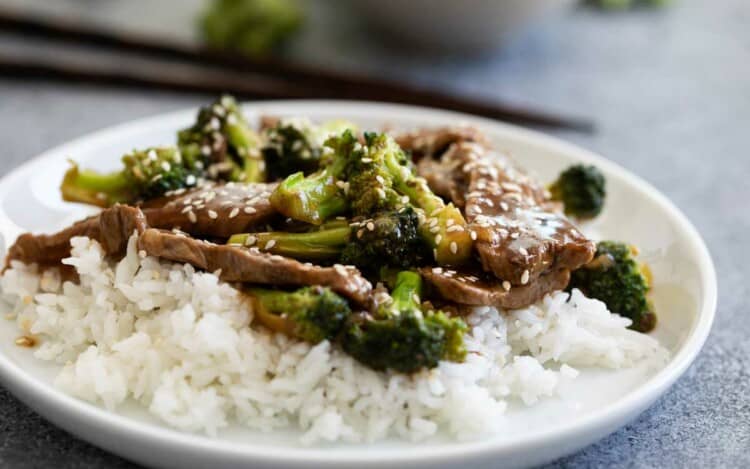 beef and broccoli over rice on a plate