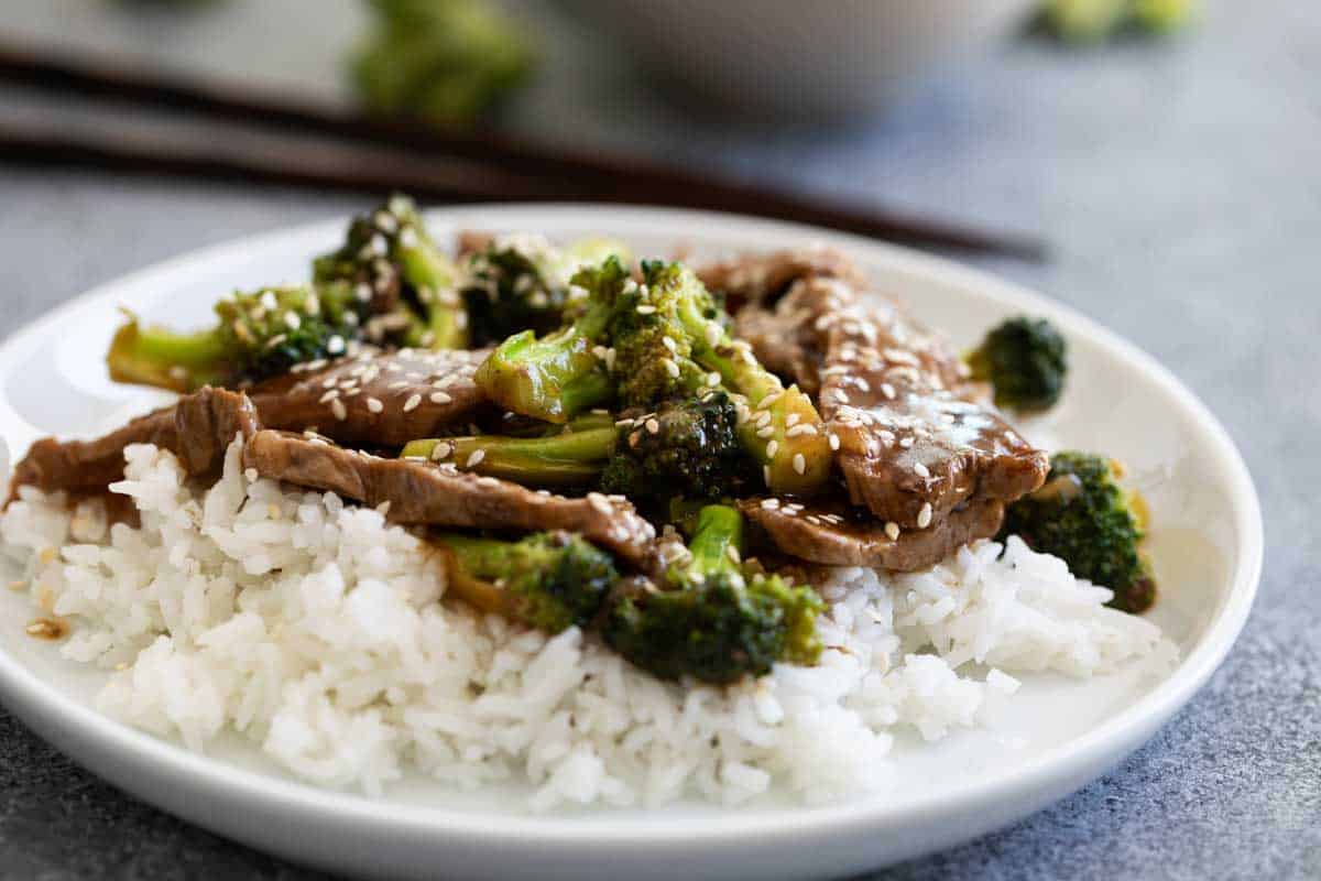 beef and broccoli over rice on a plate