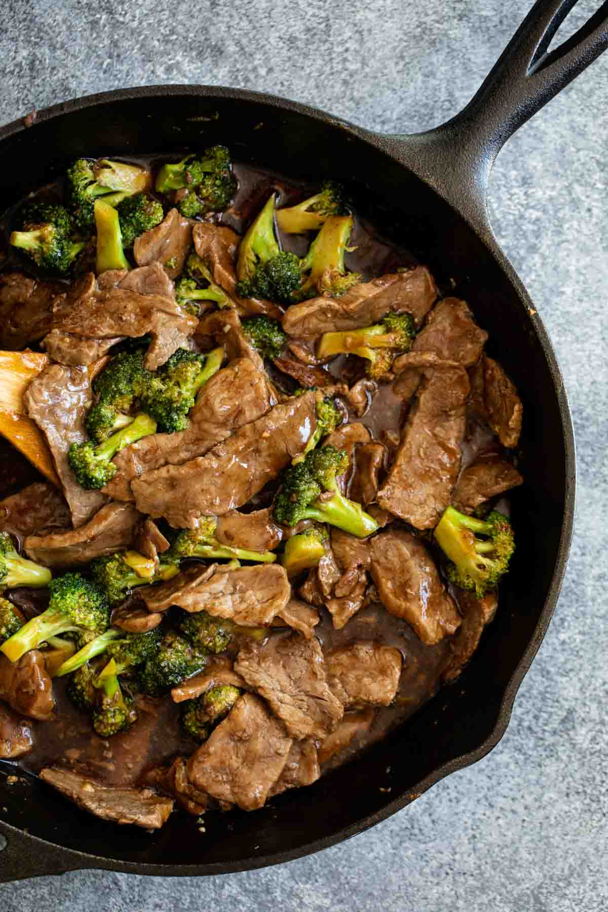 beef and broccoli in a cast iron pan