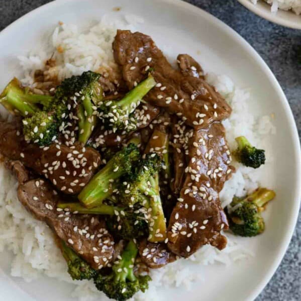 beef and broccoli sprinkled with sesame seeds over rice