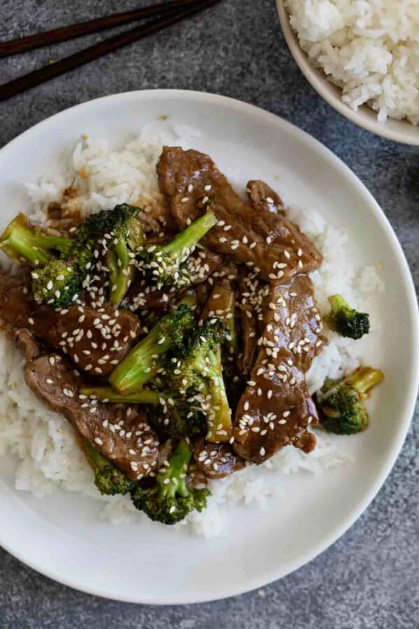 beef and broccoli sprinkled with sesame seeds over rice