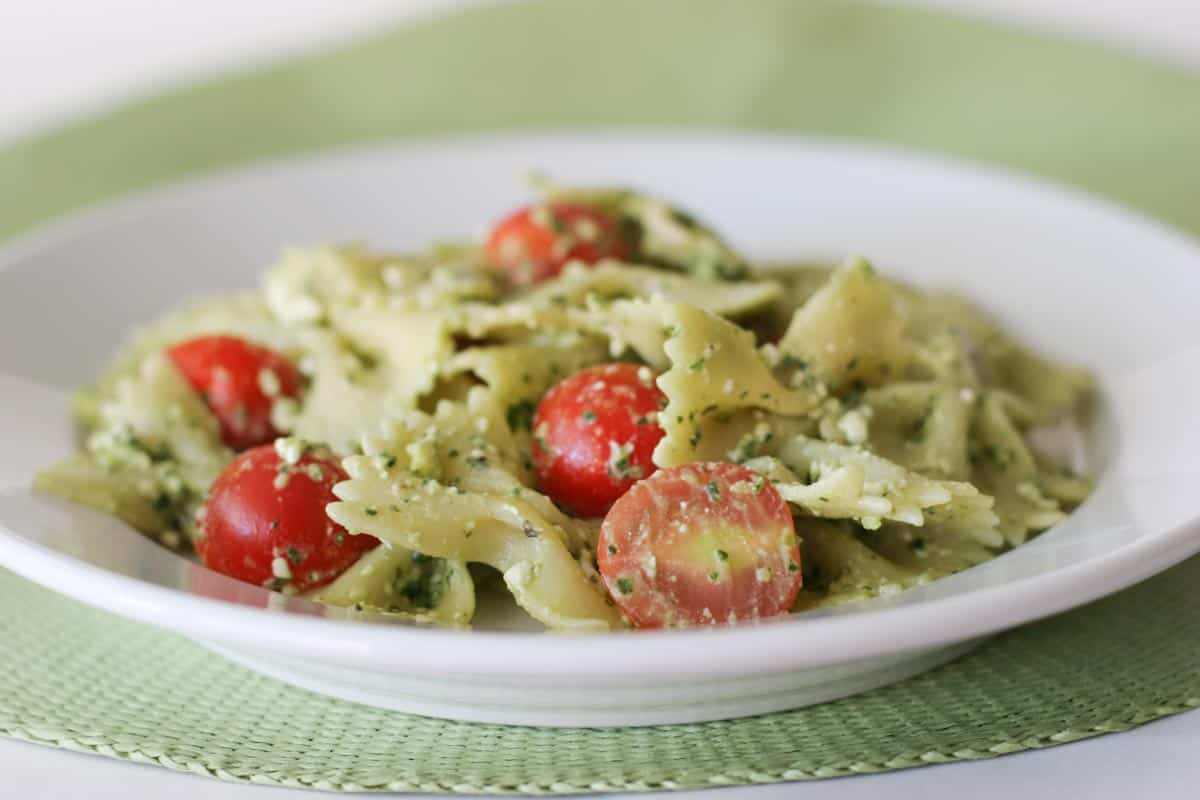 Pasta with Pesto, Feta and Cherry Tomatoes in a white bowl