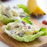 chicken lettuce wraps with pineapple, grapes and coconut on a cutting board