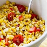 bowl filled with grilled corn salad with cherry tomatoes and peppers