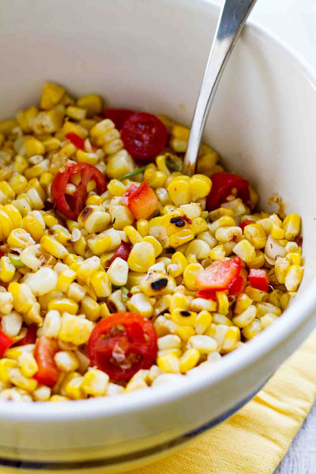 bowl filled with grilled corn salad with cherry tomatoes and peppers