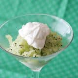 close up of kiwi granita in a glass topped with whipped cream