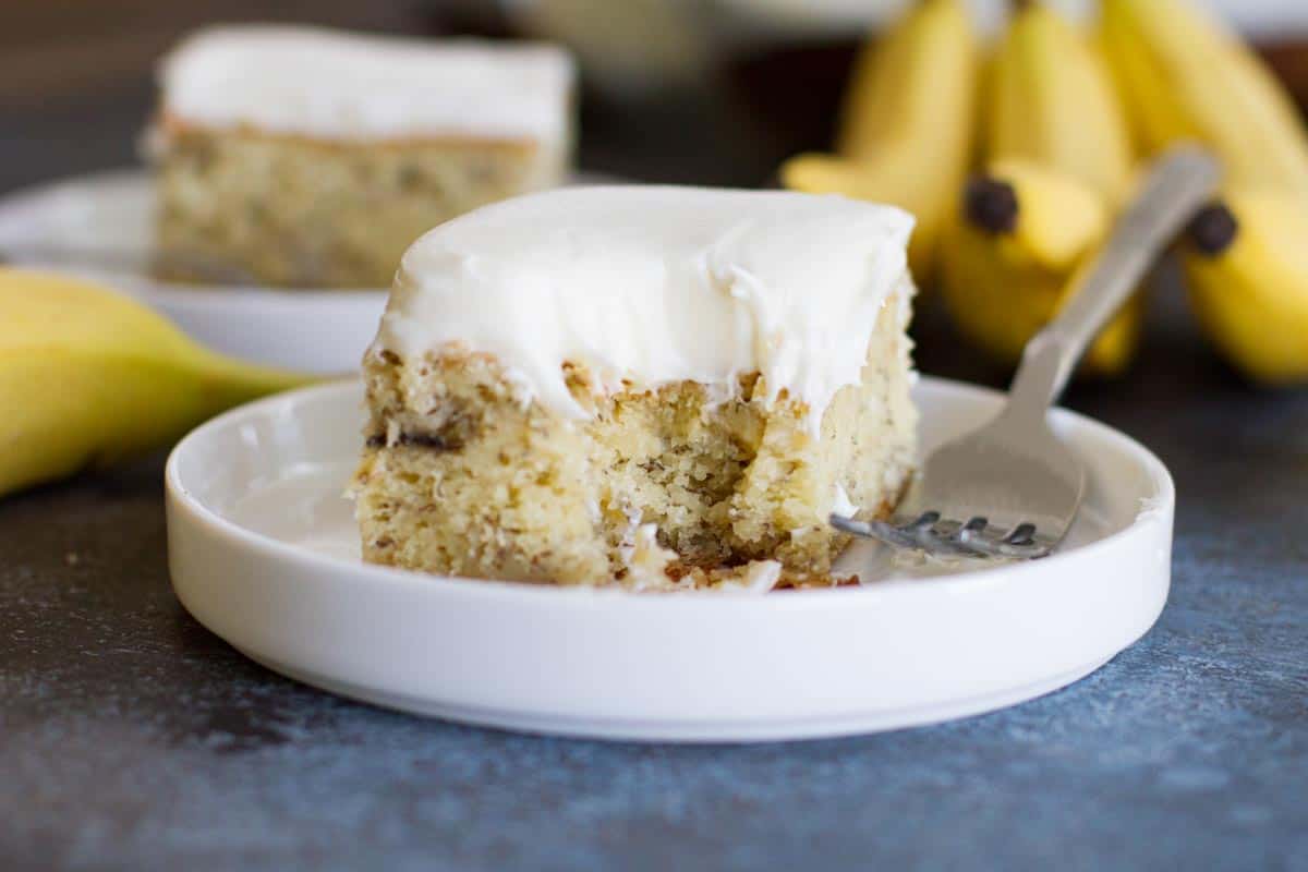 slice of banana cake with cream cheese frosting with bite taken