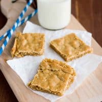 sliced Butterscotch Bars on a cutting board with milk and straws