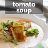 bowl of tomato soup topped with croutons and basil with text overlay