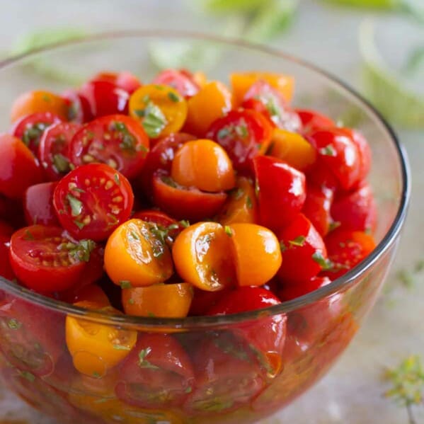 yellow and red grape tomatoes with herbs in a bowl