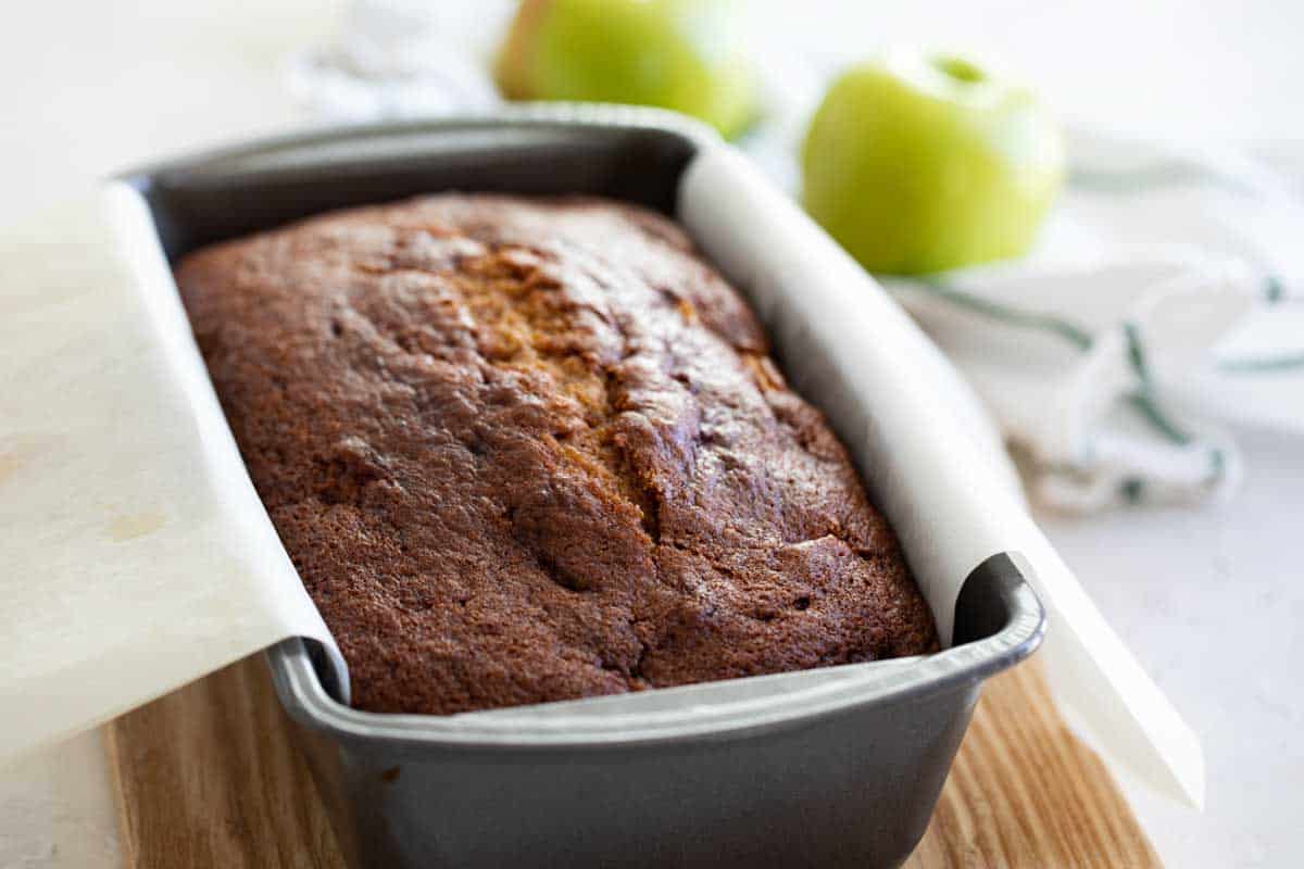 loaf of quick bread in a loaf pan with apples