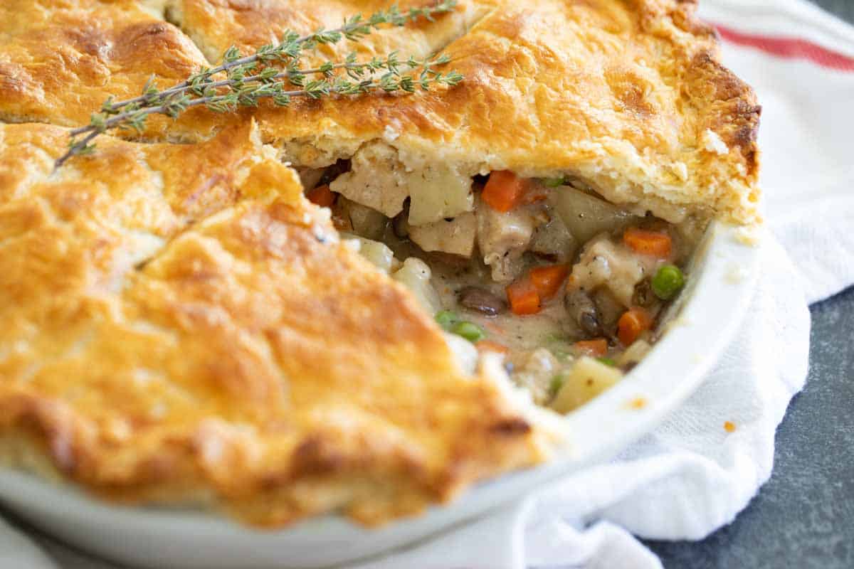 It doesn’t get more comforting than this homemade Chicken Pot Pie recipe! Tender chicken and vegetables are combined with a homemade gravy and baked between two flaky pie crusts. chicken pot pie with a slice taken out