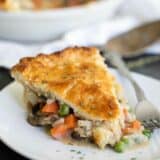 slice of chicken pot pie on a plate with the pan in the background