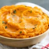 bowl filled with mashed sweet potatoes and topped with brown butter