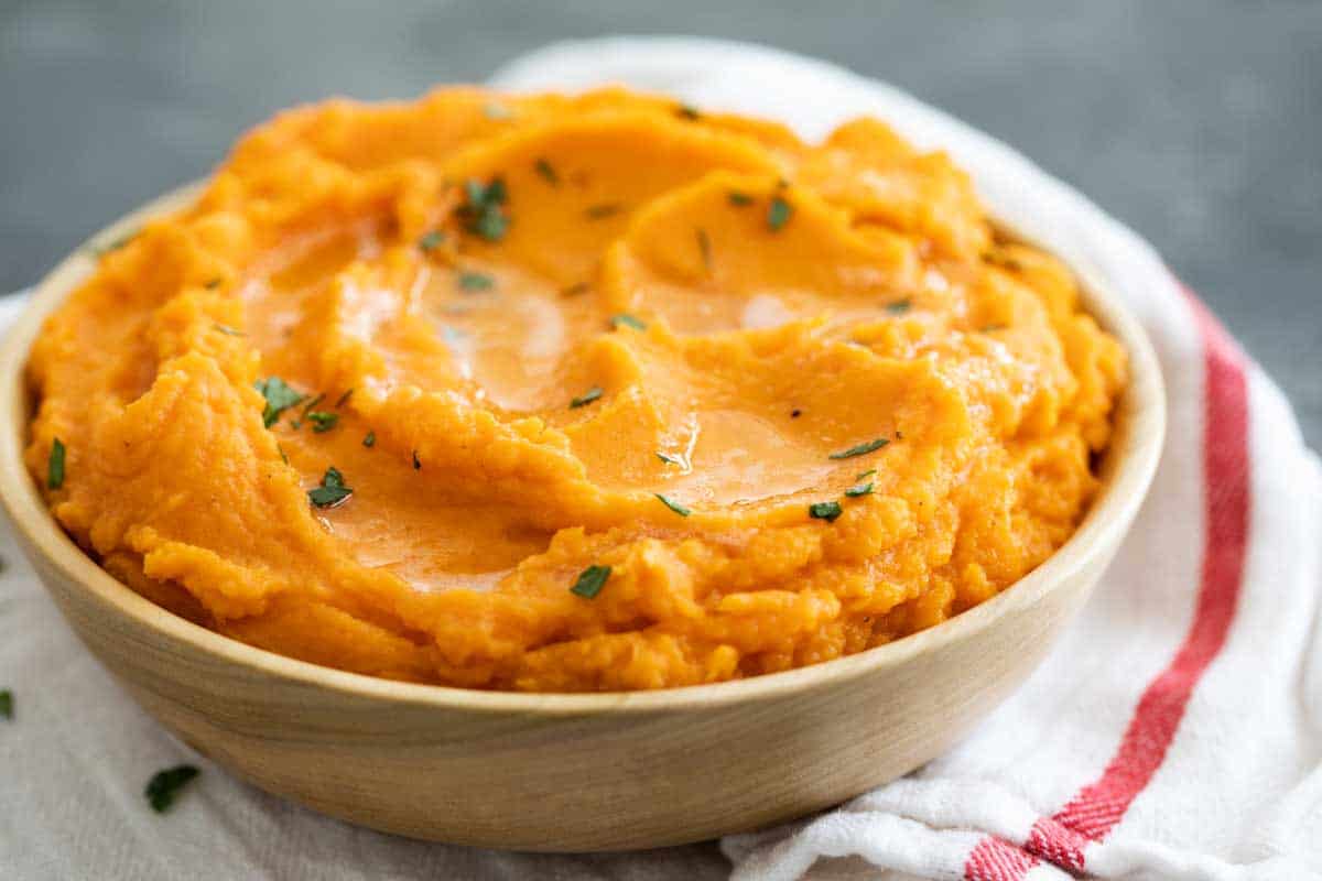 bowl filled with mashed sweet potatoes and topped with brown butter