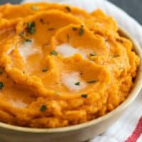 bowl of Mashed Sweet Potatoes with Brown Butter sitting on a kitchen towel