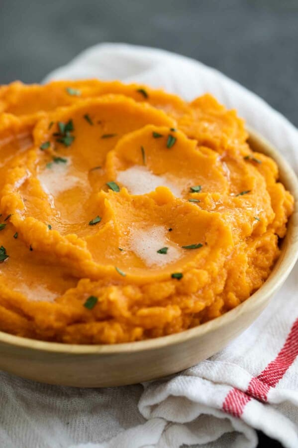 bowl of Mashed Sweet Potatoes with Brown Butter sitting on a kitchen towel