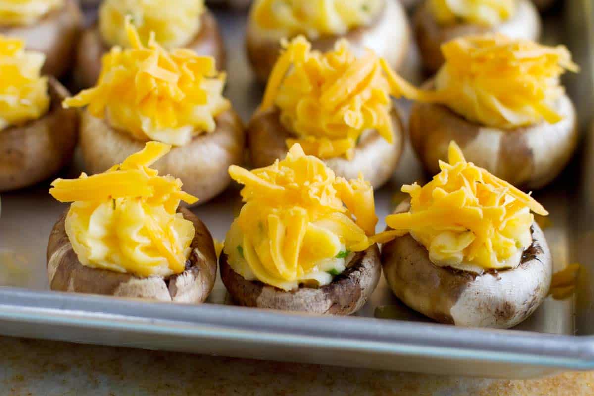 putting cheese on top of stuffed mushrooms