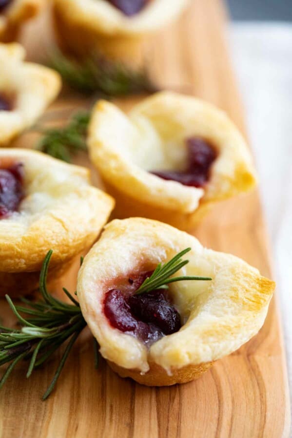 multiple cranberry brie bites on a cutting board