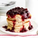 stack of spiced pancakes topped with cranberry sauce