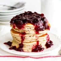 stack of spiced pancakes topped with cranberry sauce