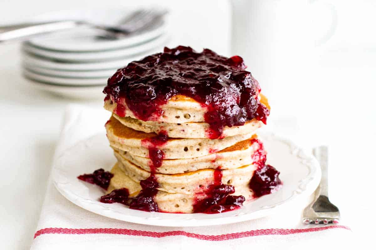 stack of spiced pancakes topped with cranberry sauce