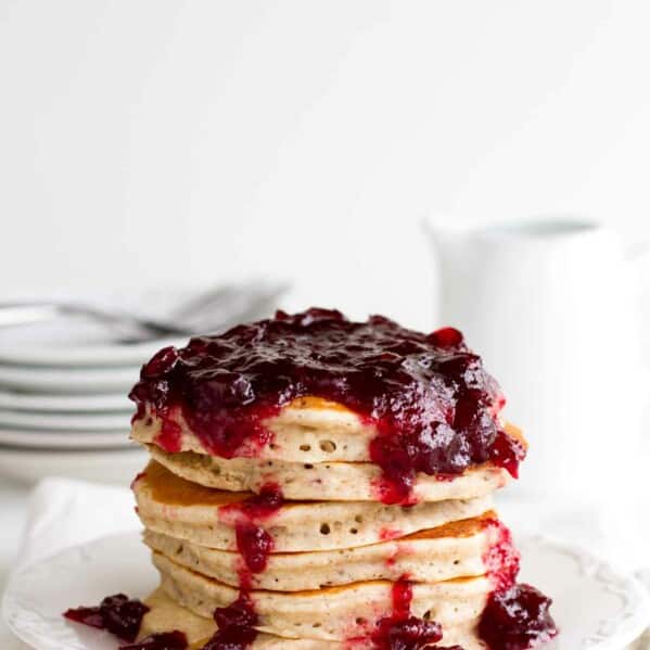 stack of Cranberry Pancakes on a white plate with white background