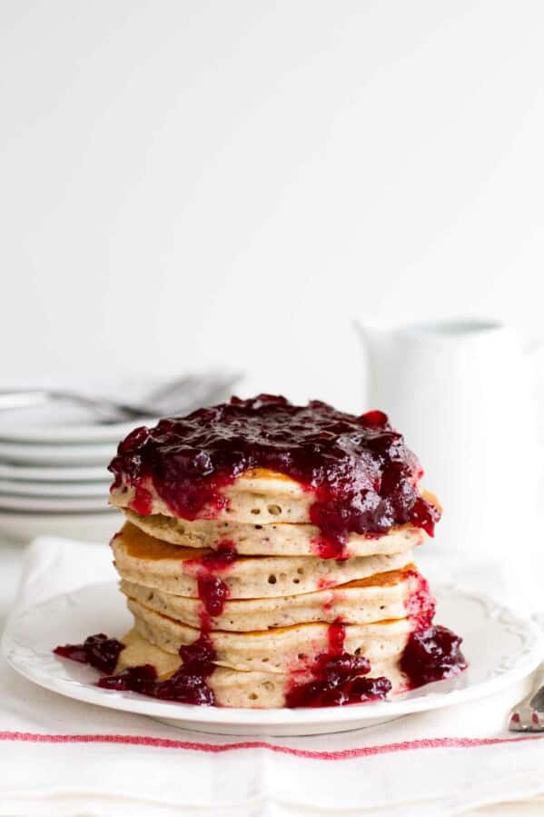 stack of Cranberry Pancakes on a white plate with white background