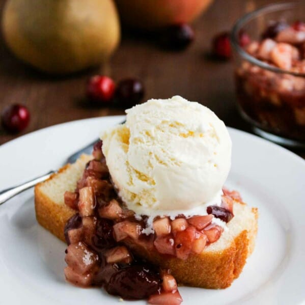 Cranberry Sauce over Pound Cake on a white plate with vanilla ice cream