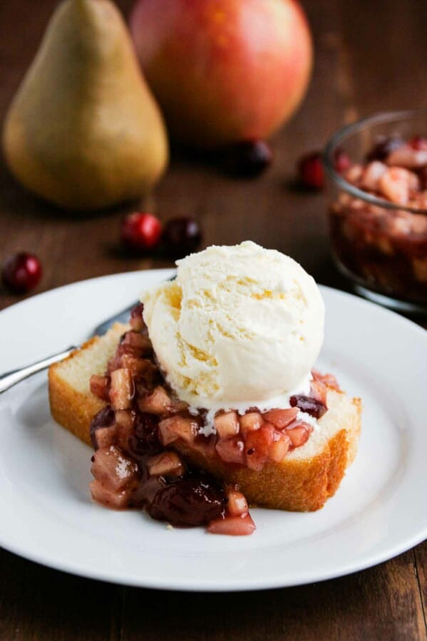 Cranberry Sauce over Pound Cake on a white plate with vanilla ice cream