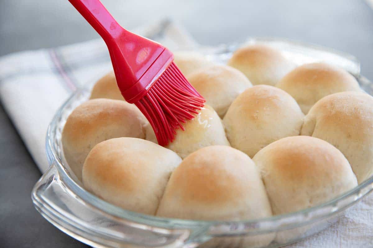 brushing butter on dinner rolls