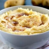 bowl of mashed potatoes topped with brown butter