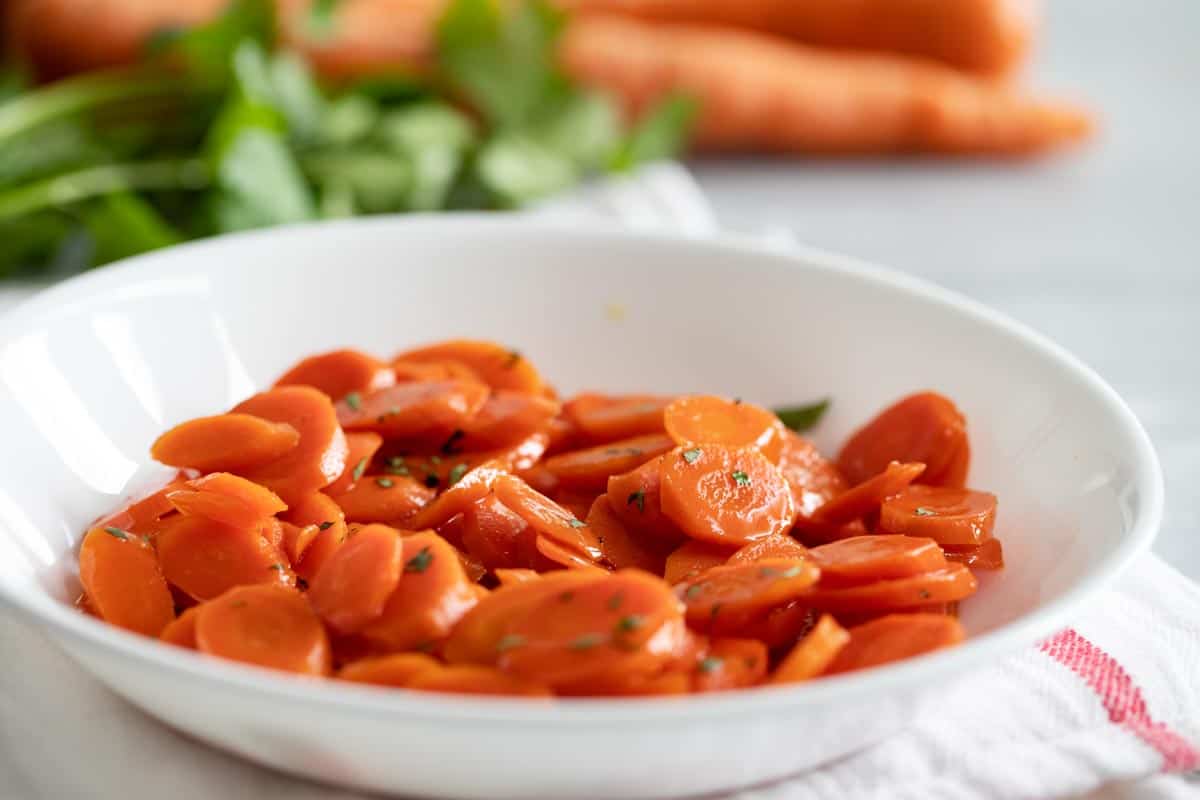 bowl with glazed carrots with parsley sprinkled on top