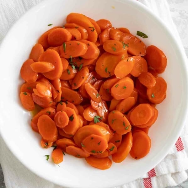 overhead view of glazed carrots in a white bowl