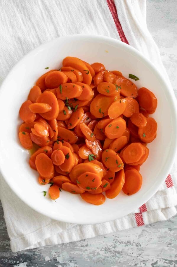 overhead view of glazed carrots in a white bowl