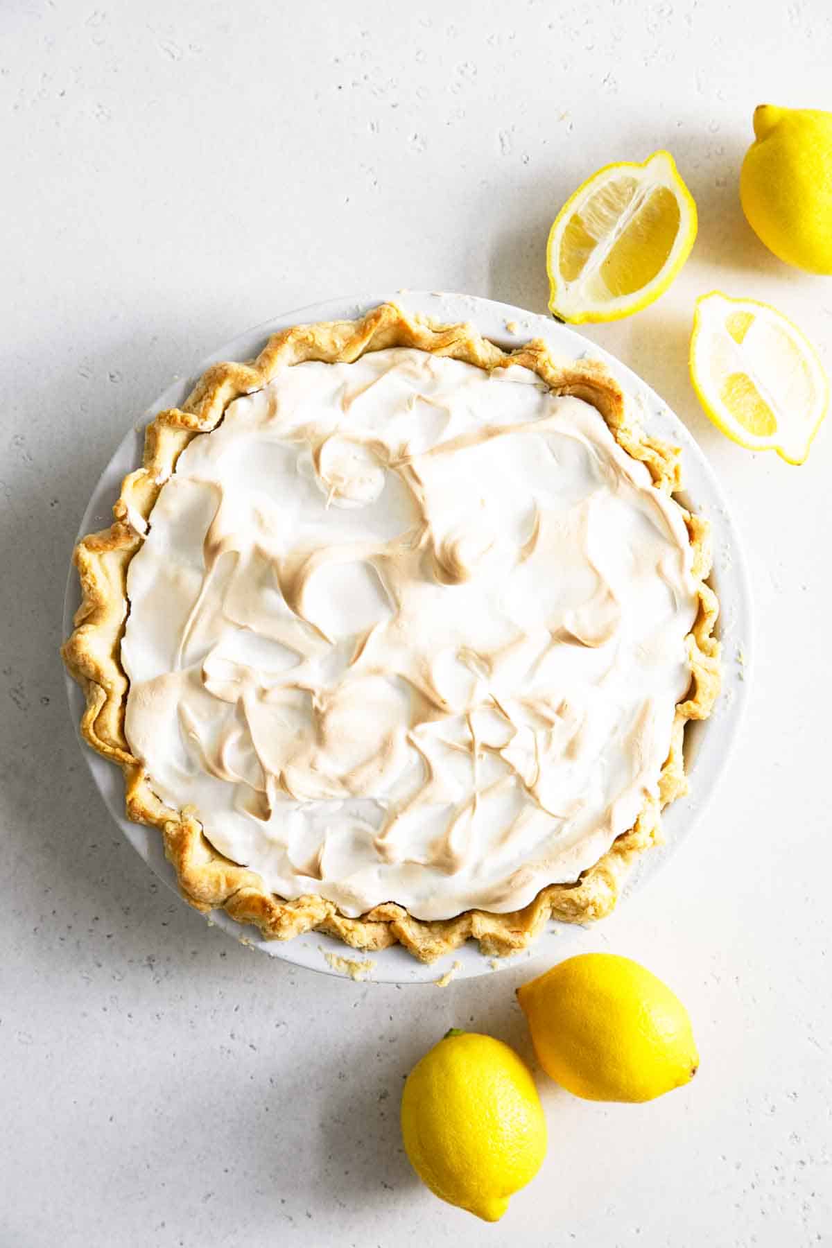 whole lemon meringue pie with lemons