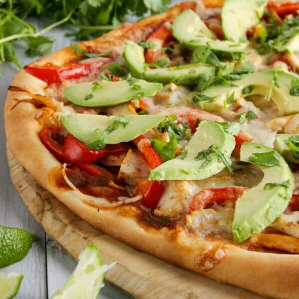 pizza topped with turkey, peppers, avocados and cheese