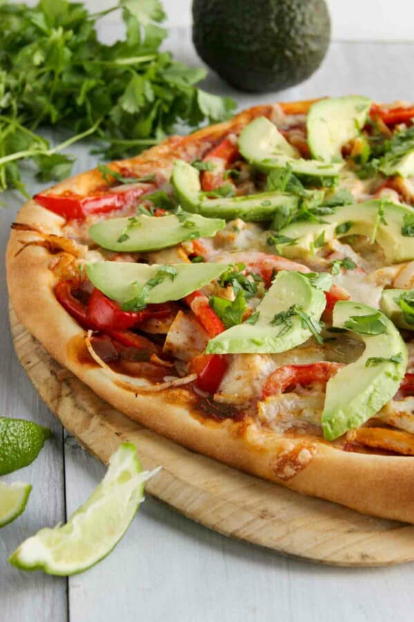 pizza topped with turkey, peppers, avocados and cheese