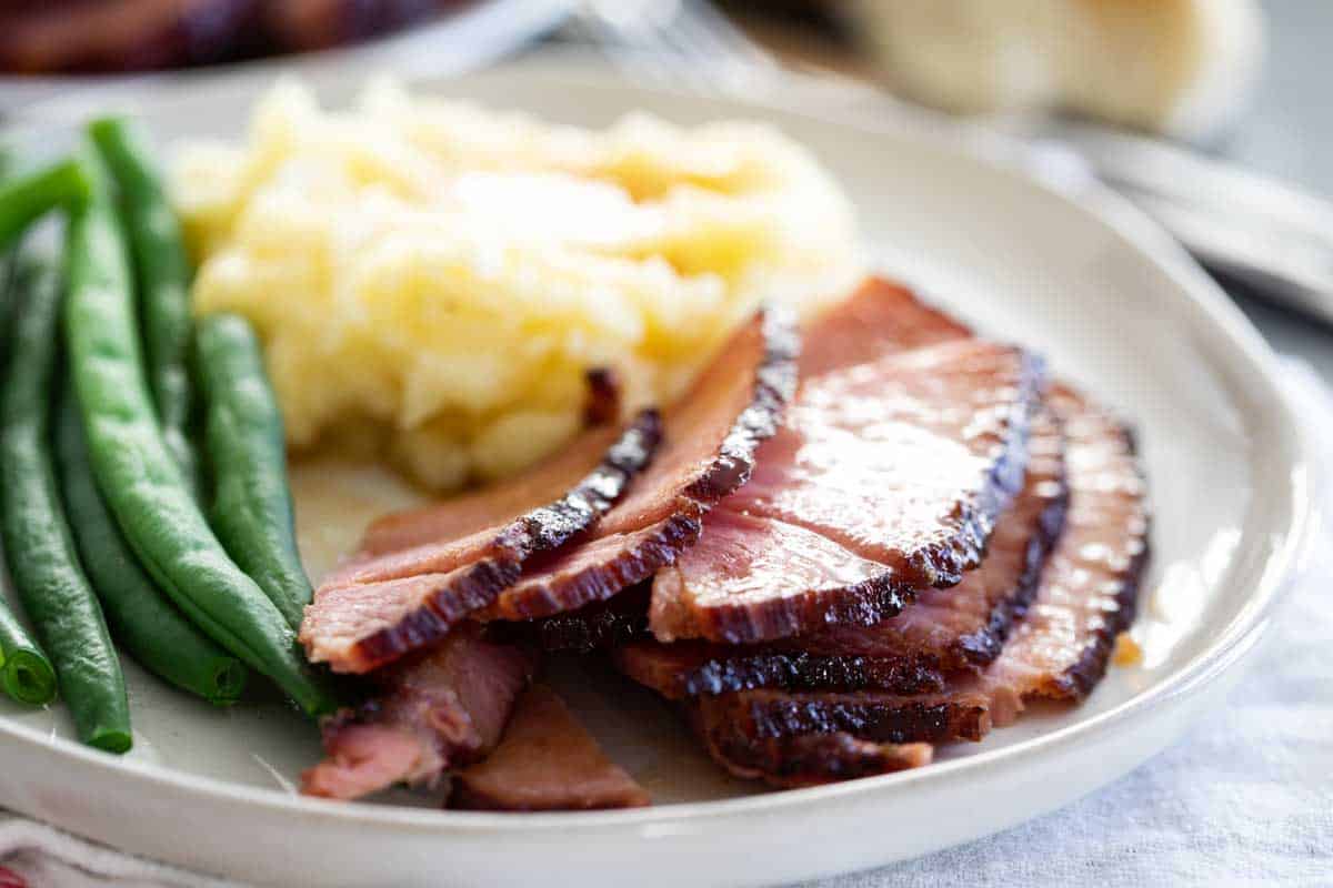 plate with slices of ham, potatoes and green beans