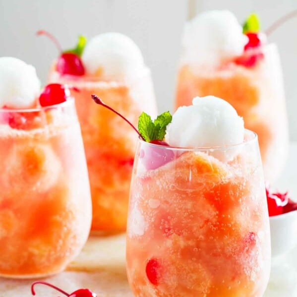 glasses of fruit freeze punch topped with sorbet and cherries