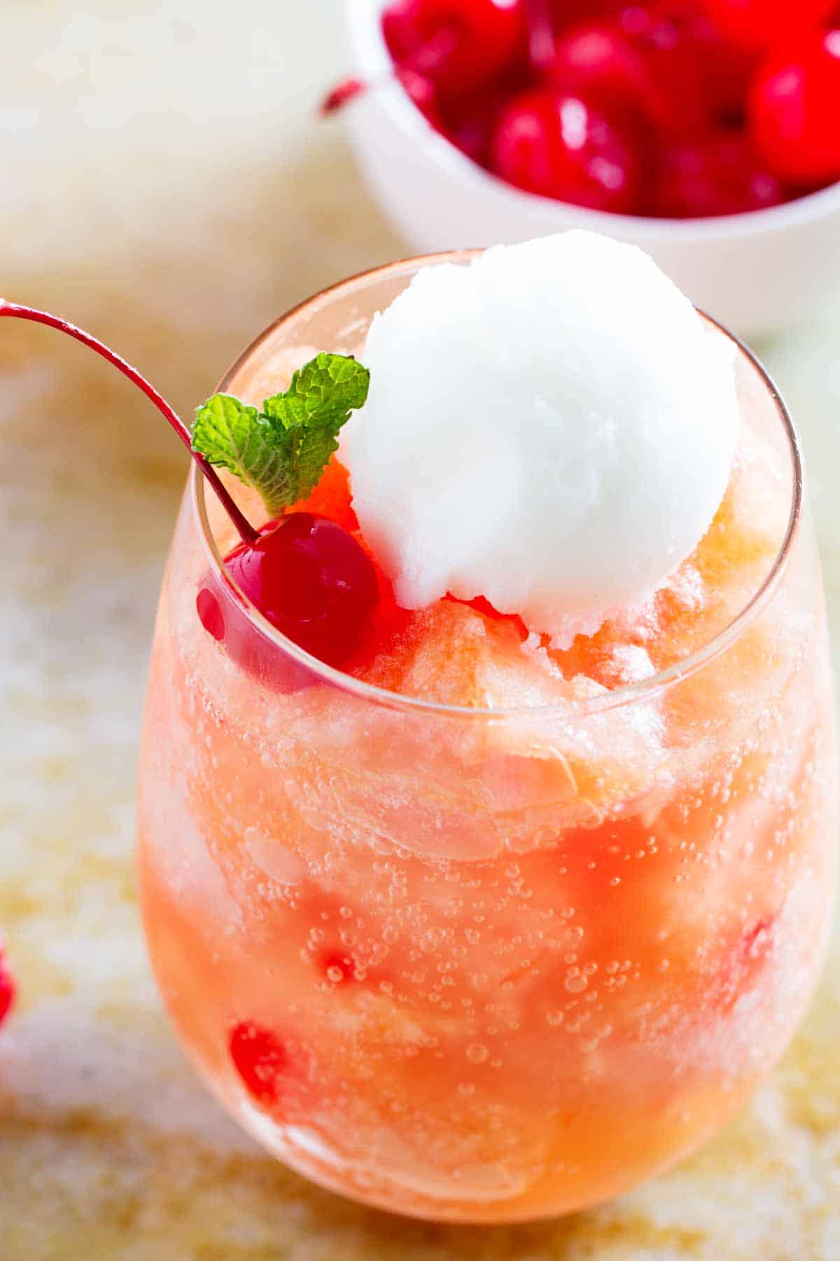 Perfect for a party, this Fruit Freeze is easy to make ahead and is a special treat for a crowd. close up of fruit freeze topped with sorbet and a cherry