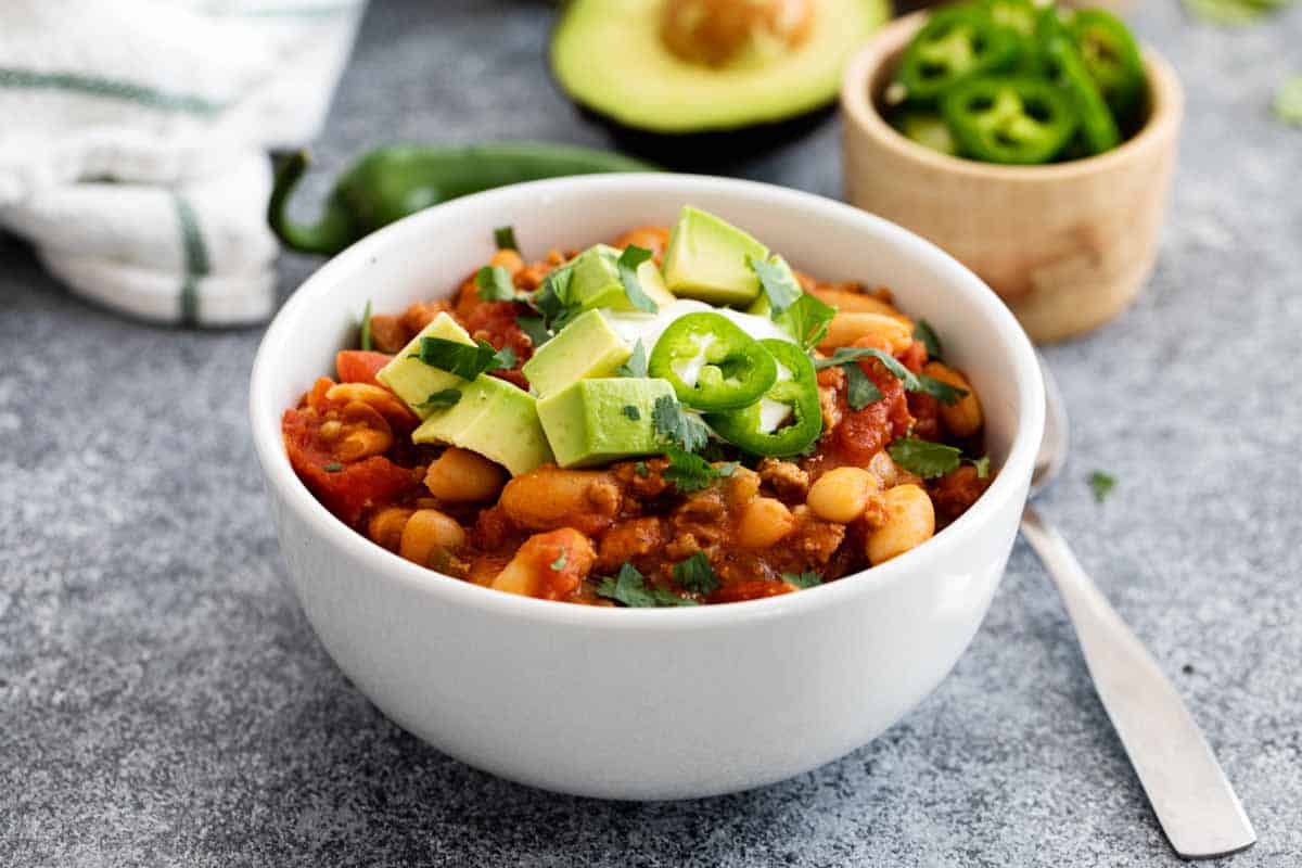 bowl of ground turkey chili with toppings